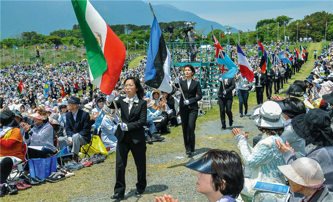 Die Flaggen von 194 Nationen werden als Teil der Gebetzeremonien zur Bühne getragen, während in über 200 Sprachen das Gebet 'Möge Frieden sein auf Erden' gespielt wird. © Tatsuru Nakayama
