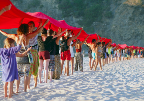 Rote Tücher und Menschenketten transportieren die wichtige Botschaft. Die Aktivisten nutzen gemeinsam mit Urlaubern den Strand als gigantische Plakatwand. © Camera