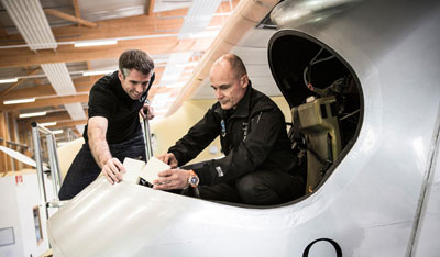 Bertrand Piccard (rechts) und Bernd Rothe probieren den Einsatz von Polyurethan-Hartschaum im Cockpit. Quelle Bayer