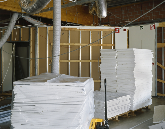 Die alten Deckenplatten sind sauber auf Europaletten gestapelt und werden so dem Recyclingprozess zugeführt. Foto: © Armstrong