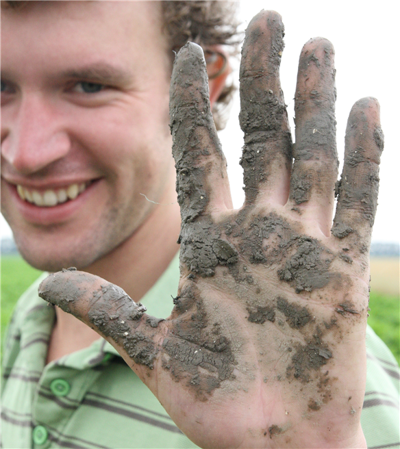 Die Hand des holländischen Biobauern Krispijn van den Dries, nachdem er Kartoffeln und Karotten ausgegraben hat. Foto: Save our Soils