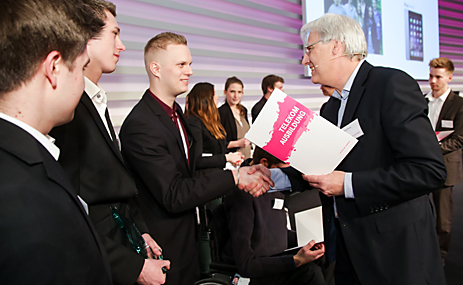 Thomas Kremer, kommissarischer Personalvorstand der Telekom, (im Vordergrund rechts) ehrt die diesjährigen Gewinner des internen Wettbewerbs für Auszubildende „Verantwortung gewinnt