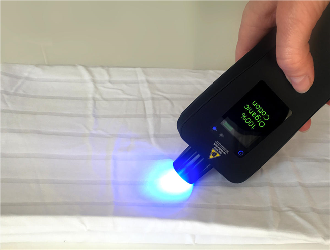 Mit einem tragbaren Spektrometer soll es möglich sein, die Markierung im Stoff auszulesen und damit den Anteil der Bio-Baumwolle festzustellen. © Tailorlux