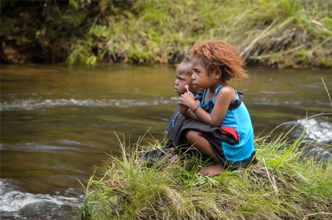 Kinder spielen am Ufer eines Flusses in Fidschi. © KIRCHE IN NOT
