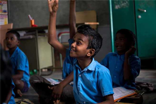 Nani, 10, in seinem Klassenzimmer in einem kleinen ländlichen Dorf in Andhra Pradesh in Südindien. Nani ist ein 10-jähriger Junge, der die Schule im Alter von 9 Jahren abgebrochen hätte, wenn Pala, ein Mitarbeiter von Save the Children, nicht eingegriffen hätte. Nani besucht nun regelmäßig die Schule, anstatt auf den Baumwoll- und Chilifeldern zu arbeiten. Er sagt, er lernt gerne, und diese Schule macht ihn zum glücklichsten von allem in seinem Leben. © Rajan Zaveri / Rettet die Kinder