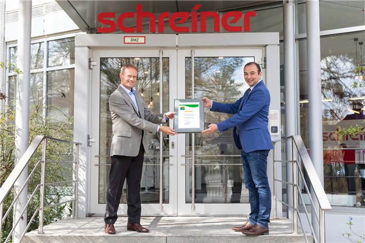 Oberschleißheims Bürgermeister Markus Böck freut sich, die Urkunde für den Umwelt- und Klimapakt Bayern an den Leiter des Umweltschutzmanagements bei der Schreiner Group, Dr. Thomas Gulden, zu übergeben. © Schreiner Group