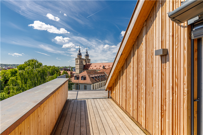 Das historische Stadtzentrum Bayreuths ist um ein inoffizielles Wahrzeichen reicher. Gegenüber des Neuen Schlosses und unmittelbar hinter dem Sitz der Regierung von Oberfranken errichtet die VIDA HolzProjekt GmbH in Zusammenarbeit mit holzius einen Wohngebäudekomplex der Gebäudeklasse 5 – in innovativer und zeitgemäßer Holzbauweise. © VIDA HolzProjekt GmbH