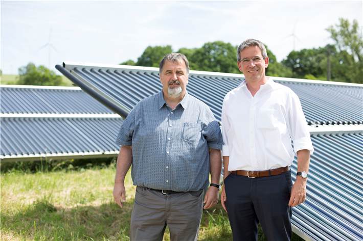 Ortsbürgermeister Volker Wichter und Michael Uhle, Klimaschutzmanager im Rhein-Hunsrück-Kreis, vor dem Solarthermie-Feld, welches das Nahwärmenetz von Neuerkirch-Külz unterstützt. © Energieagentur Rheinland-Pfalz 