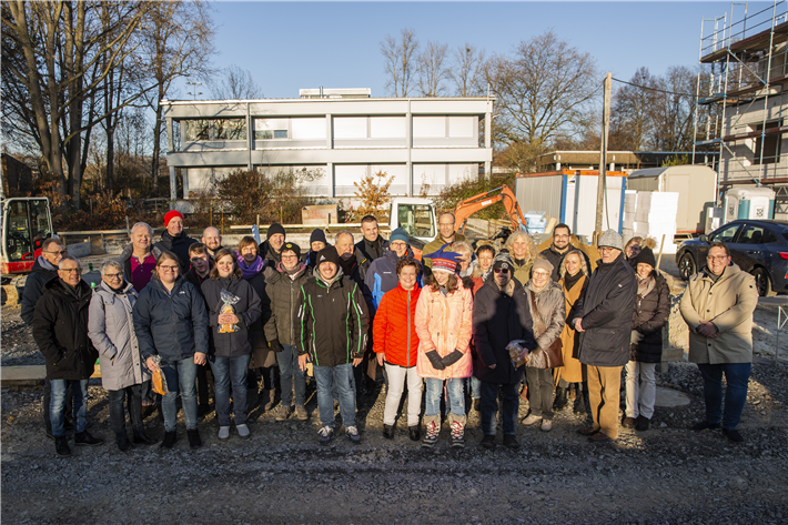 Kinder und Eltern der Elterninitiative und Mitarbeitende der Spar- und Bauverein eG auf der Baustelle der Klimaschutzsiedlung Ewige Teufe © Patrick Temme 