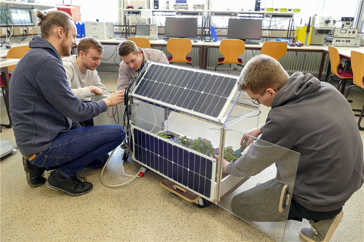 Die vier Elektrotechnikstudenten eint ihr Interesse an erneuerbaren Energien. Auf dem Dach ihres Gewächshauses und an der Außenwand installierten sie daher jeweils ein Solarmodul. © FH Münster/Jana Bade