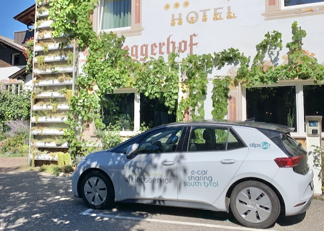 Wenn die SüdtirolMobil-Card für kostenlosen Nahverkehr nicht reicht, steht ein Elektroauto vor der grünen Fassade zur Verfügung © Kai Platz