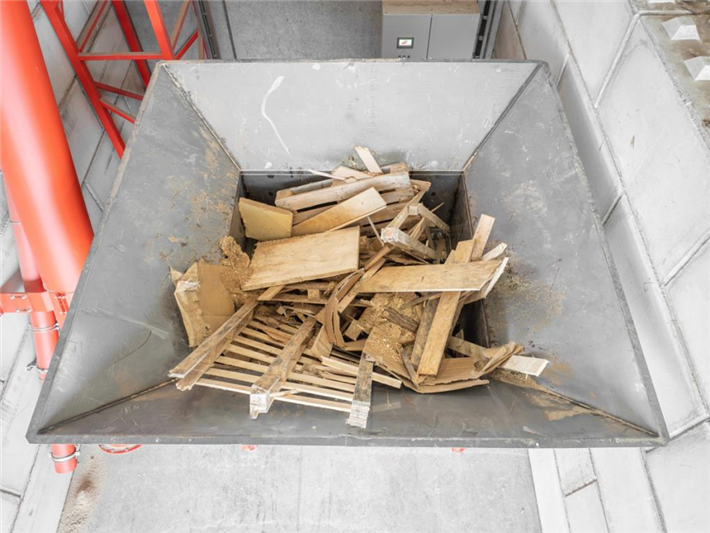 Holzabfälle im großen Trichter des Zerkleinerers. © WEIMA