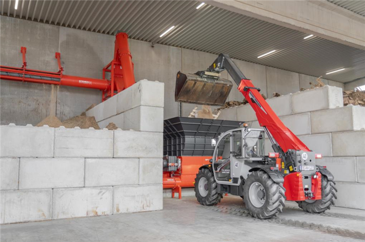 Holzreste werden mit dem Teleskoplader in den großen Trichter befördert. © WEIMA