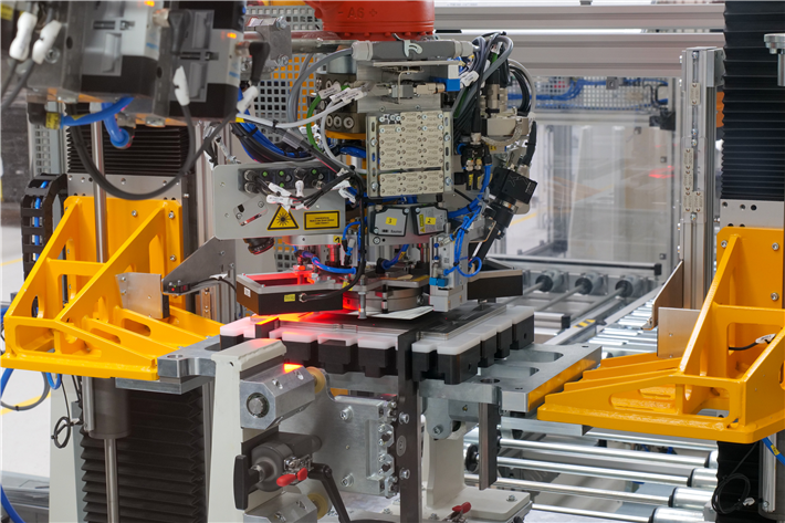 Die Stacking-Anlage der Referenzfabrik.H2: Hubeinheit für Stapel (orange), Werkstückträger mit Führungen (Mitte), Transfersystem, Greifer mit Fließsauger, Abstreifer und zwei Kameras zur Lagekorrektur. © Fraunhofer IWU