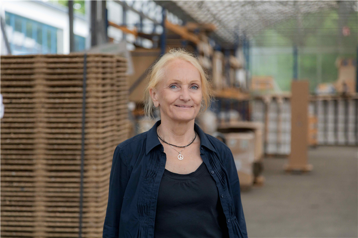 Eva Danneberg in der Lagerhalle von WERKHAUS. Dank des firmeneigenen Stecksystems lassen sich viele Produkte flach verpacken – das spart Platz beim Versand und reduziert Verpackungsmaterial. &copy; WERKHAUS